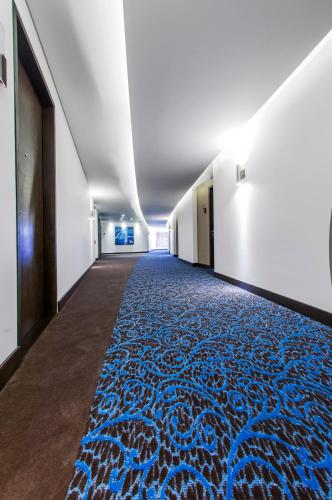 a long hallway with a blue and white carpet at Hotel Morrison Usaquén in Bogotá