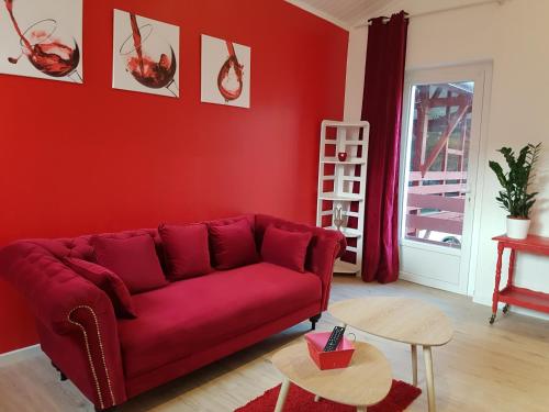 a red living room with a red couch and a table at L'Impératrice - en cœur de Bastide de Geaune in Geaune