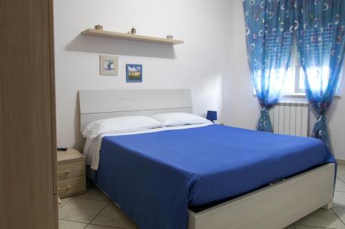 a bedroom with a blue bed and blue curtains at Campi Flegrei House in Naples