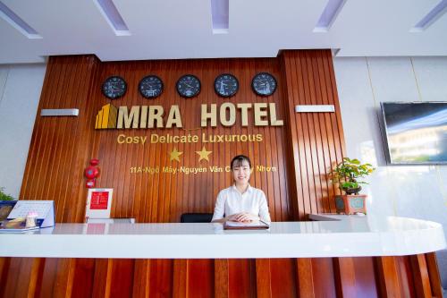 a woman sitting at a counter in an office at Mira Hotel Quy Nhơn in Quy Nhon