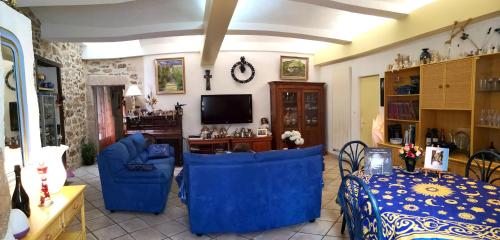 a living room with blue chairs and a tv at Moulin De Cornevis Bed and Breakfast in Privas