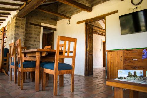 a dining room with a table and chairs and a tv at Remanso El Tobal in Tibasosa