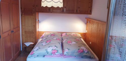 a small bedroom with a bed with pink flowers at Civico 10 in Candide