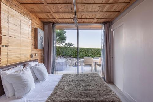 une chambre avec un lit et une porte coulissante en verre dans l'établissement Cottages Domaine du Grand Bec, à Villerville