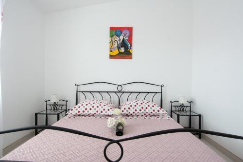 uma cama com um urso de peluche sentado em cima dela em Apartments Iva em Trogir