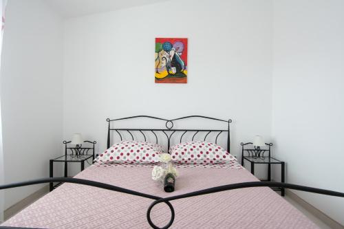 a bed with a teddy bear sitting on top of it at Apartments Iva in Trogir