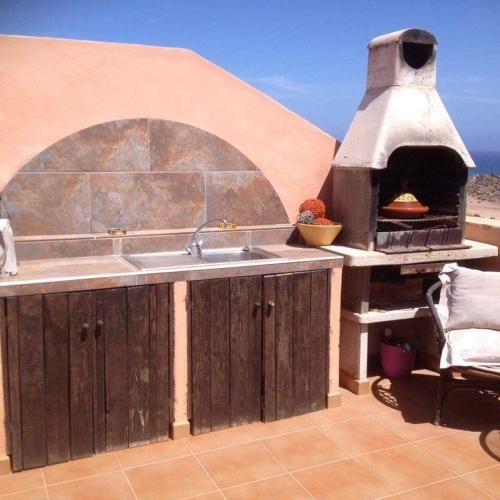 a kitchen with a pizza oven on a patio at RESIDENCE NUEVO HORIZONTE in Costa de Antigua