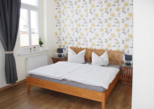 a bedroom with a bed and a floral wall at Ferienhaus Brockenbahnblick in Wernigerode