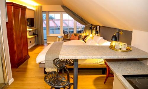 a hotel room with a bed and a kitchen with a counter at Nordseehotel Kröger in Langeoog