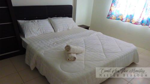 a white bed with white sheets and towels on it at COMEL SEA VIEW HOMESTAY in Kuantan