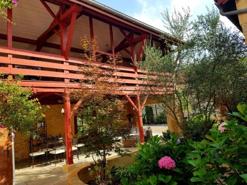 a patio with a wooden pergola and some plants at L'Impératrice - en cœur de Bastide de Geaune in Geaune