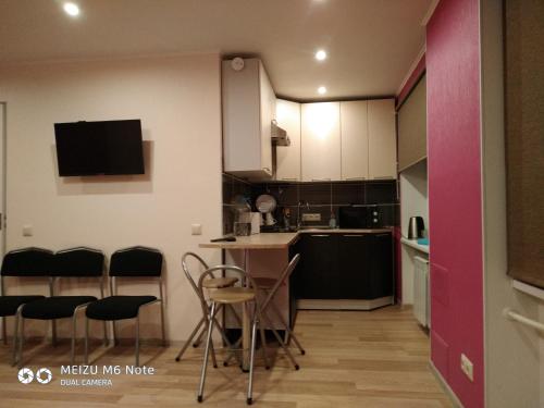 uma pequena cozinha com mesa e cadeiras em Sparta Apartments Malmi em Narva