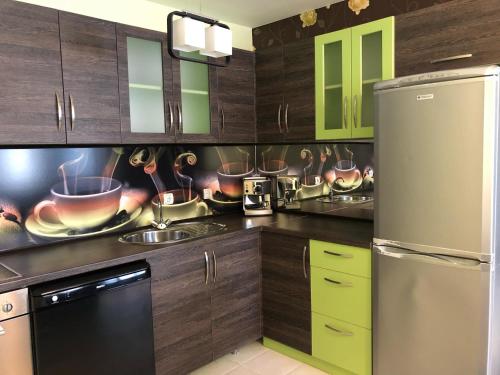 a kitchen with wooden cabinets and a stainless steel refrigerator at GALA APARTMENT in Veliko Tŭrnovo