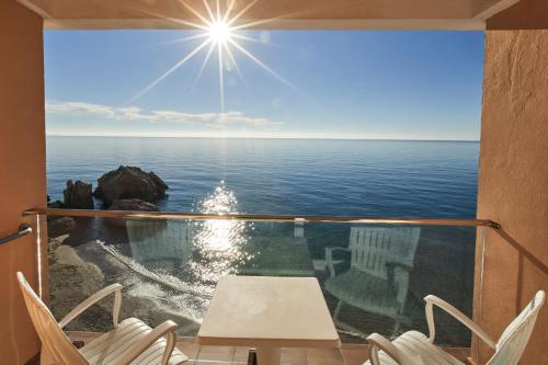 a view of the ocean from a balcony with chairs at Hotel Balcón de Europa in Nerja