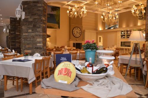 a restaurant with tables and chairs and a clock on the wall at Georgalas Rest Apartments in Nea Kalikratia