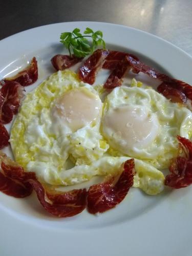 a plate of eggs and bacon on a plate at Hostal D'Éller in Éller
