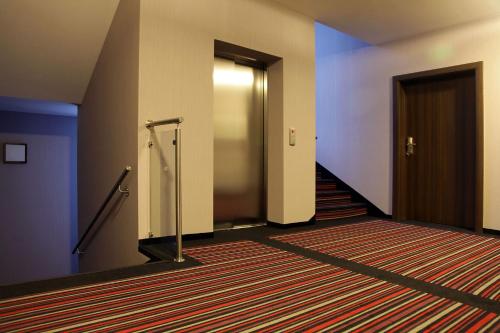 an empty hallway with doors and a carpet at Hotel Camelot in Szczawno-Zdrój