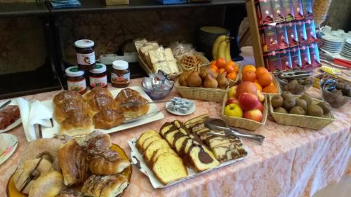 a table topped with lots of different types of pastries at Palazzo Moraschi Subiaco in Subiaco