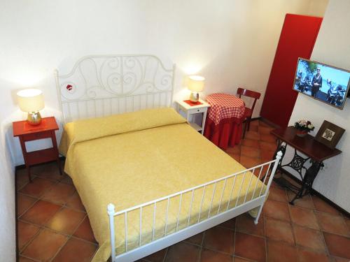 a bedroom with a bed and two tables and a tv at Apartments Ruby in Funtana