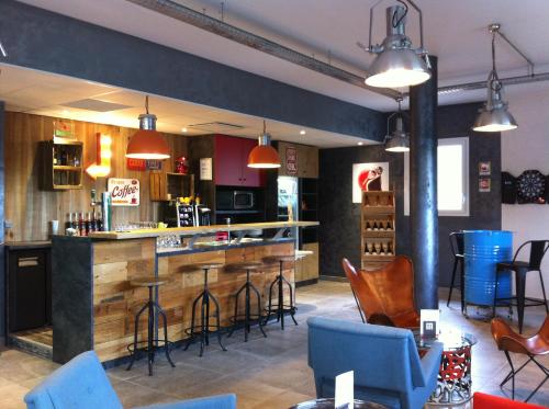 un bar en un restaurante con mesas y sillas azules en ibis Styles Vierzon en Vierzon