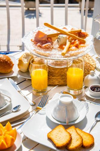 a table topped with plates of food and orange juice at La Gasparina in Positano