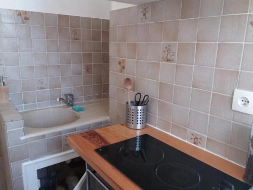 Il comprend une petite cuisine équipée d'une cuisinière et d'un évier. dans l'établissement Nice Centre, Charmant Studio, à Nice