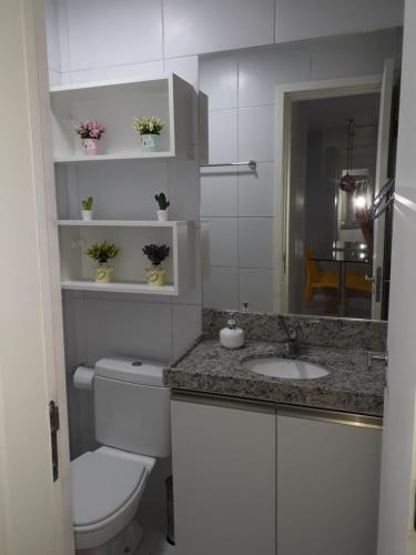 een witte badkamer met een toilet en een wastafel bij Porto de Galinhas - Muro Alto Condomínio Clube in Porto De Galinhas