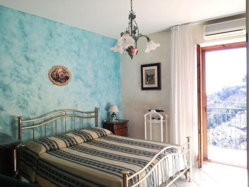 1 dormitorio con 1 cama con pared azul en Domus Gaia, en Amalfi