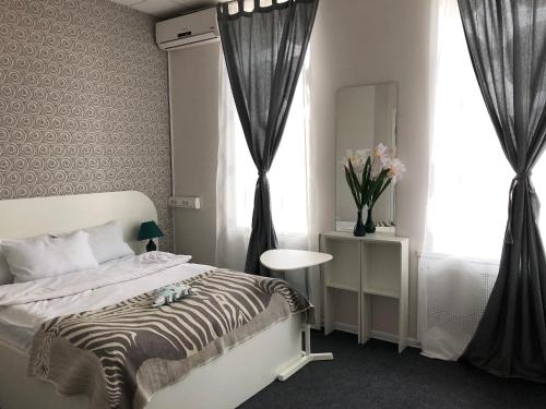 モスクワにあるミニホテル リンゼーのベッドルーム1室(ベッド1台、花瓶1本付)