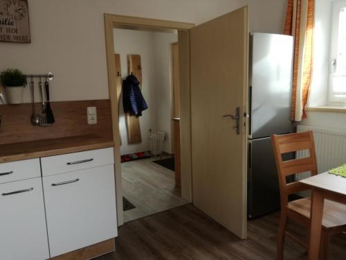 a kitchen with a white refrigerator and a table at Landhof Ella - Ferienhaus vor den Toren Salzburgs in Petting