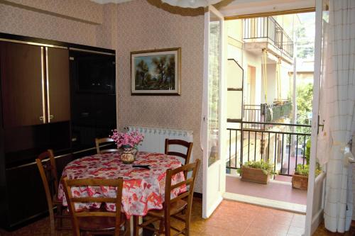a dining room with a table and chairs and a balcony at Casa vacanza Francesca in Levanto