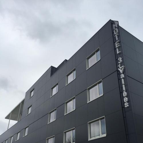 a building with a sign on the side of it at HOTEL LES 3 VALLÉES in Saran