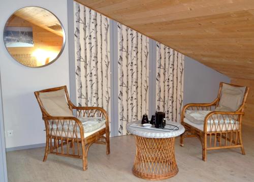 two chairs and a table in a room with a mirror at Chambres d'Hôtes Le Nid d'Iroise in Lanildut