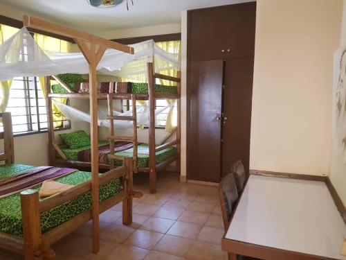 a room with two bunk beds and a table at Climbers Home in Moshi