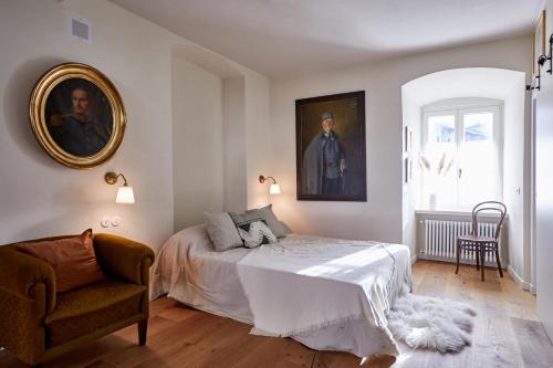 - une chambre avec un lit, une chaise et un tableau dans l'établissement Castello Fai, à Fai della Paganella