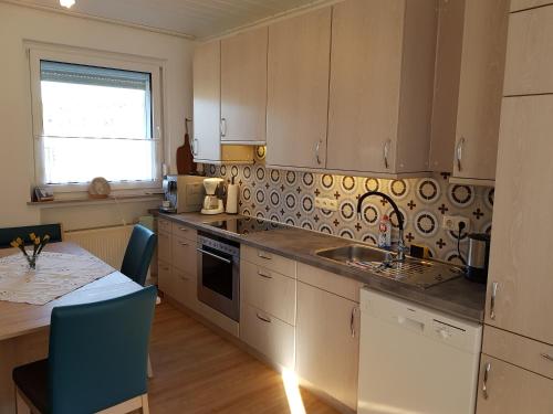 a kitchen with a sink and a table with a tableablish at Ferienhaus "Am Gehre" in Bad Berleburg