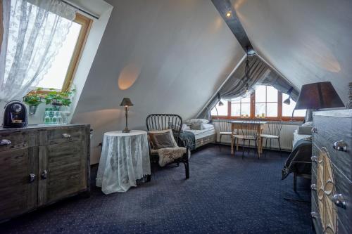 - un salon mansardé avec une table dans l'établissement Willa Grandeus, à Bukowina Tatrzańska