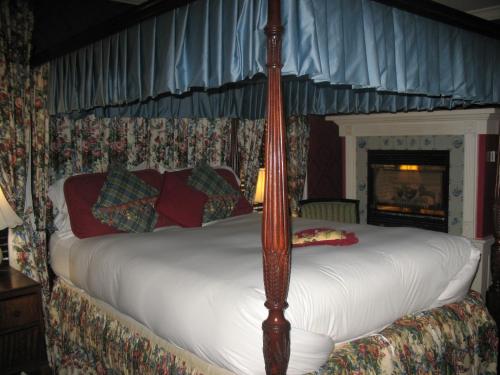 a bed in a bedroom with a fireplace in a room at A Cambridge House Inn in Cambridge