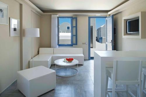 a living room with a white couch and a table at Acroterra Rosa Luxury Suites & Spa in Akrotiri