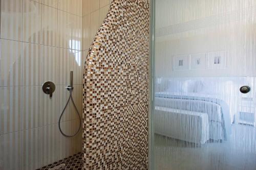 a bathroom with a shower with a bed in it at Acroterra Rosa Luxury Suites & Spa in Akrotiri