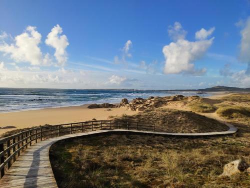 un camino de madera a una playa con el océano en Casa do patín, en Palmeira