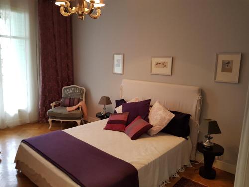 a bedroom with a bed with pillows and a chair at Capitole Bleu in Nice