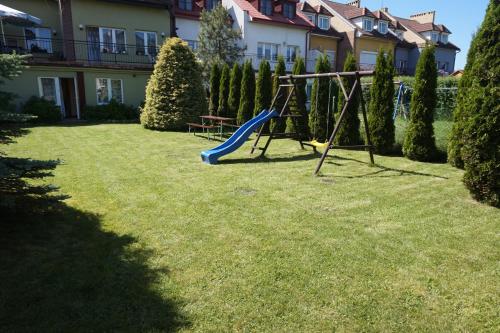 un parque infantil en un patio con tobogán en SunRise Mielno, en Mielno