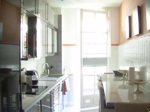 a kitchen with a counter and a sink and a window at Capitole Bleu in Nice