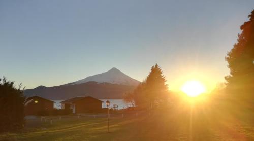 a sunset with a mountain in the background at Cabañas & Piscina Rucamalen in Ensenada