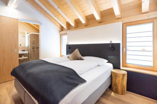 a bedroom with a large bed and a window at Wolfegg Appartement - Cafe - Bistro in Warth am Arlberg