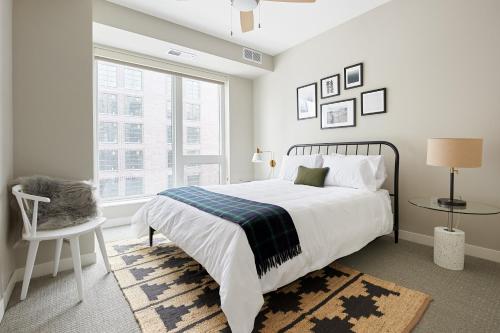 a white bedroom with a large bed and a window at Sonder at East End in Minneapolis