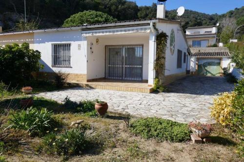 una pequeña casa blanca con entrada de piedra en Casa Can Emilia, en Tossa de Mar