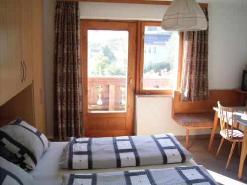 a bedroom with a bed and a window and a table at Haus Panorama in Lermoos