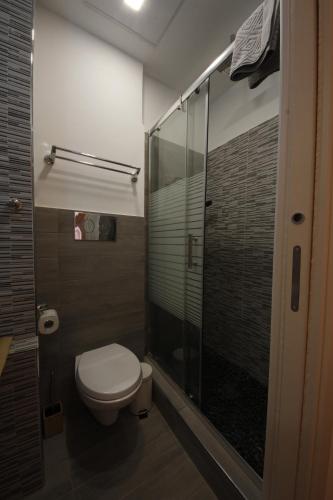 a bathroom with a toilet and a glass shower at NicaDomus B&B in Licata